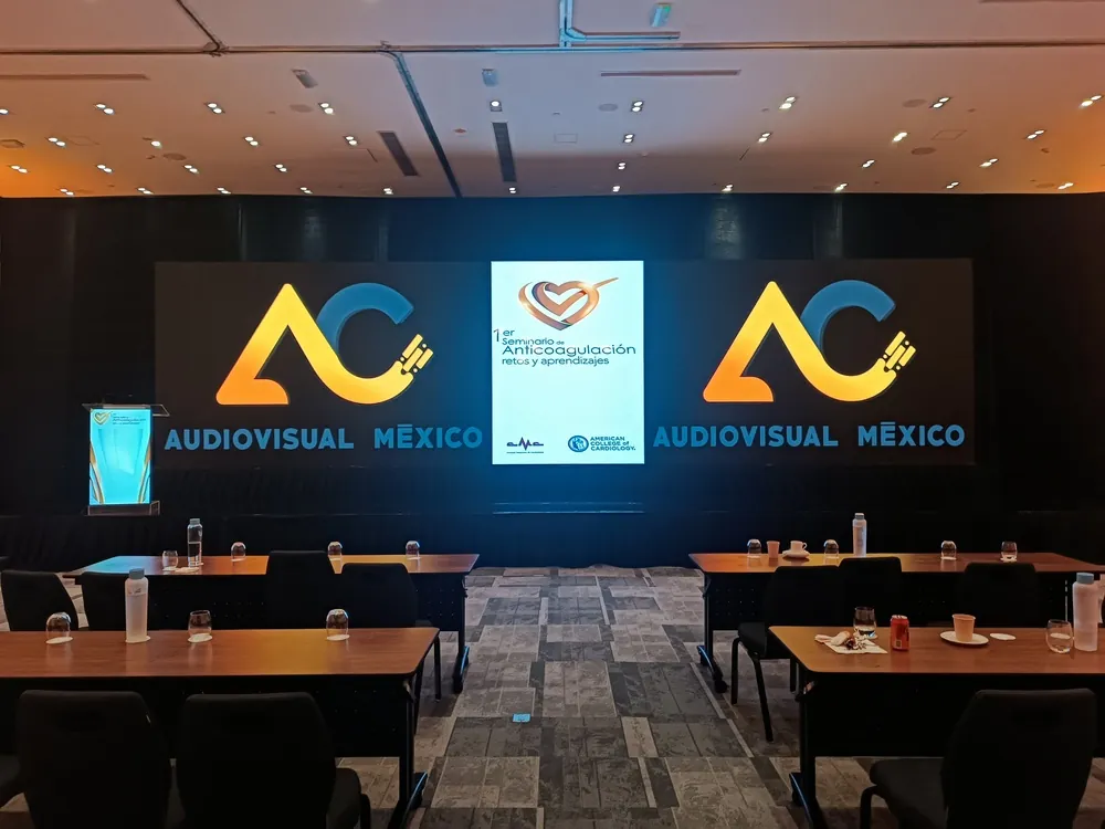 Corporate stage with screens and AC Audiovisual logos
